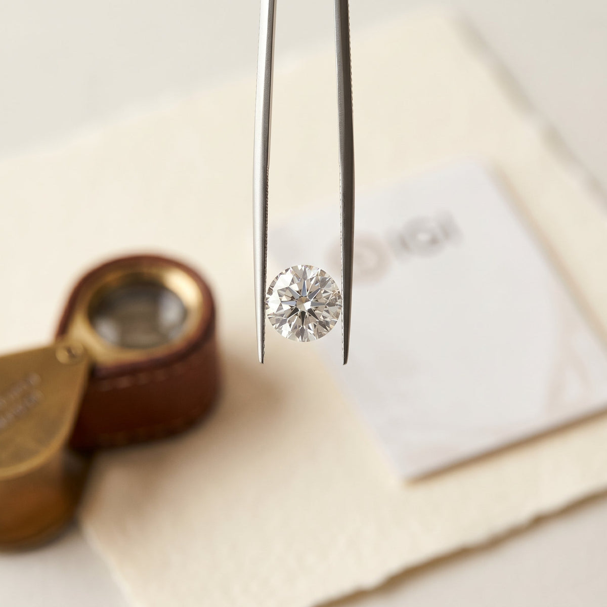 IGI certificate and lab-grown diamond under a jeweller's loupe