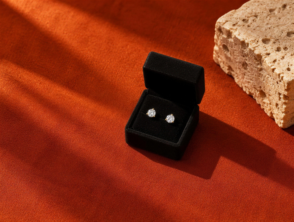 My First Diamond studs in a black box on burnt orange linen